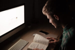 Focused Young Man Studying And Working In A Dimly Lit Room